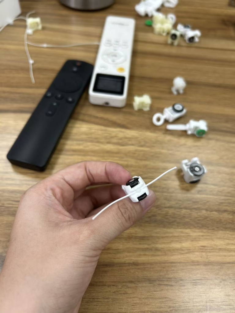 curtain-motor-components-assembly-parts-quality-inspection Curtain motor components and accessories disassembled for quality inspection - showing precision-engineered parts including motor assembly, runners, and mechanical components