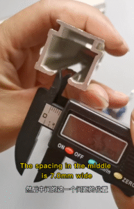Measuring spacing width of aluminum curtain runners with digital caliper showing 7.0mm