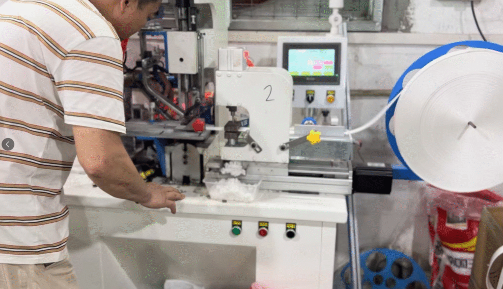 Automated machine for attaching wheels to curtain runner body - shows industrial automation equipment used in heavy-duty runner production with control panel and monitoring display