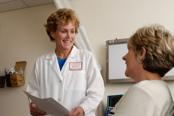 patient-consultation-healthcare-provider Healthcare provider consulting with patient in medical examination room with privacy curtain system